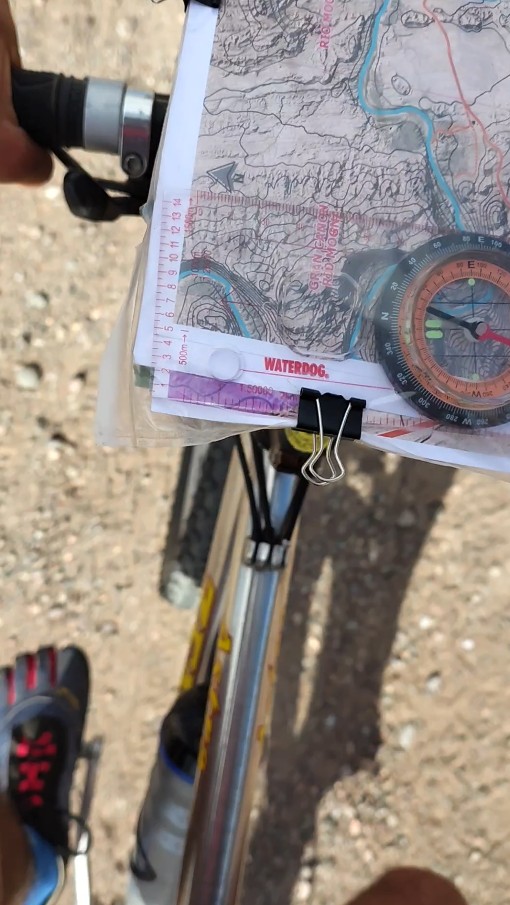 El portamapas en acción, durante la carrera. Se aprecia el montaje de los mapas y la brújula, dentro de un folio. img